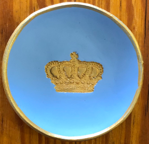 Pictured is a light blue blessing bowl with a gold crown in the center of it. The rim of the clay bowl is also gold. Made in Oxford, MS by artist Carrie Cox and sold at The Hare & The Hart.