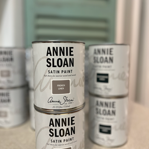 Pictured is a stack of cans of Annie Sloan Chalk Paint.