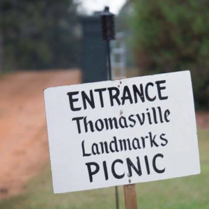 Pictured is a sign that reads, "ENTRANCE Thomasville Landmarks PICNIC."