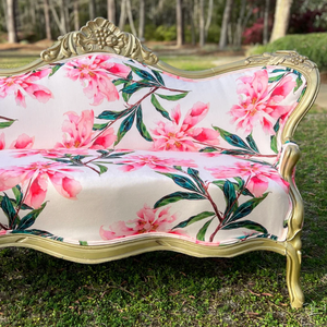 Pictured is an antique couch painted gold and upholstered with a bright floral fabric.