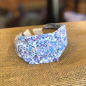 Pictured is Liberty London Flat Headband in the pattern Wiltshire Blue sold at The Hare & The Hart in downtown Thomasville, Georgia. It is a headband made from purple, blue, and white floral fabric.