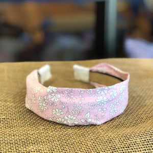 Pictured is Liberty London Flat Headband in the pattern Pink Capel sold at The Hare & The Hart in downtown Thomasville, Georgia. It is a headband made from pink and white floral fabric.