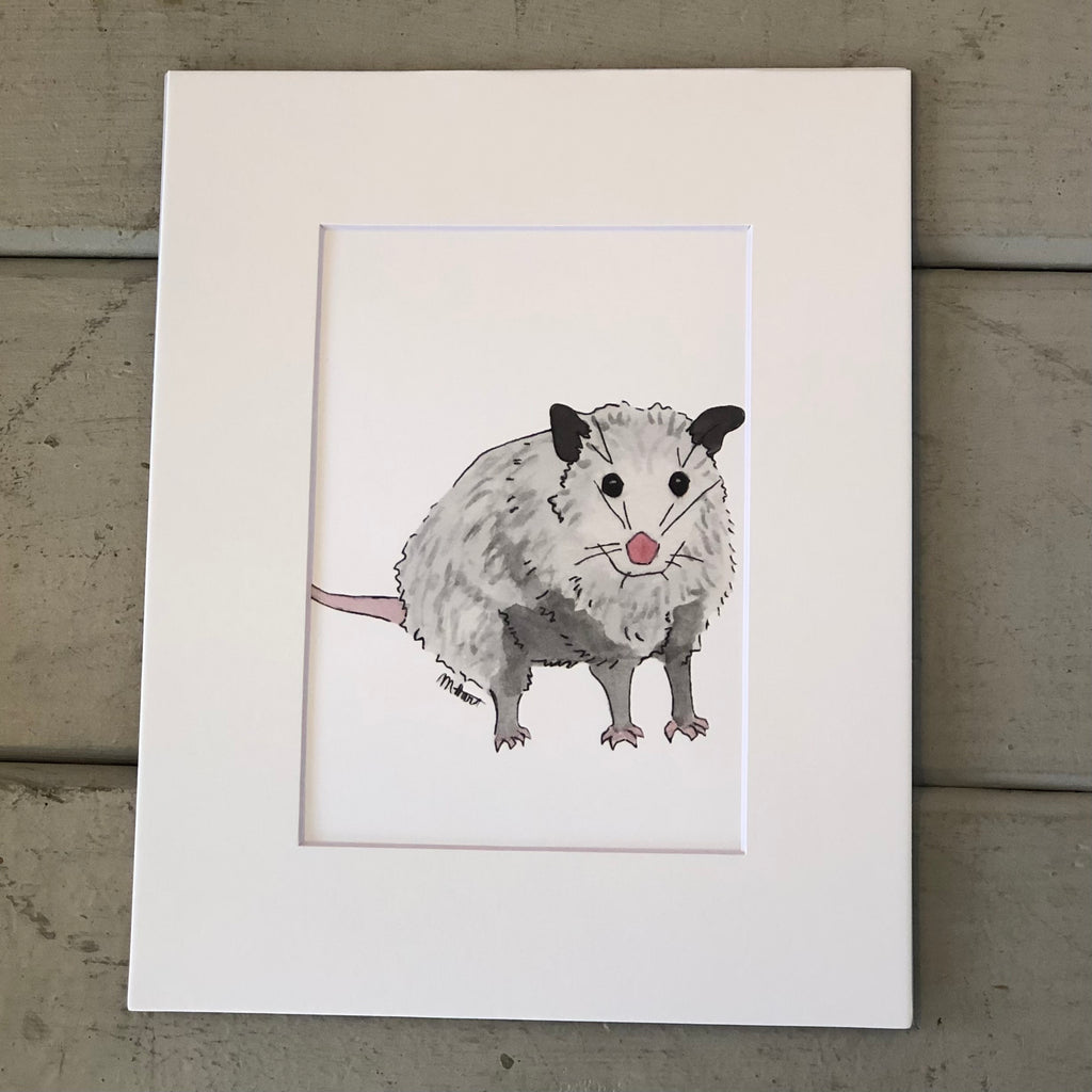 Pictured is a print designed by artist Maddie Hart and sold at The Hare & The Hart in downtown Thomasville, Georgia. It is an 5" x 7", matted to 8" x 10", print of a watercolor possum.