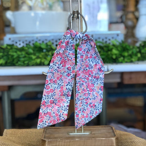 Pictured is Liberty London Hair Scarf in the pattern Wiltshire Pink sold at The Hare & The Hart in downtown Thomasville, Georgia. It is a scarf made from blue and pink floral fabric.