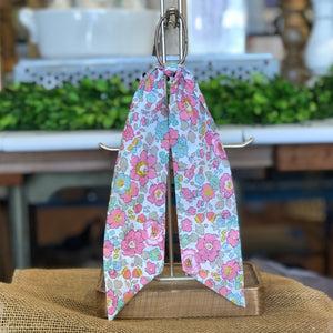 Pictured is Liberty London Hair Scarf in the pattern Betsy Pink sold at The Hare & The Hart in downtown Thomasville, Georgia. It is a scarf made from blue and pink floral fabric.