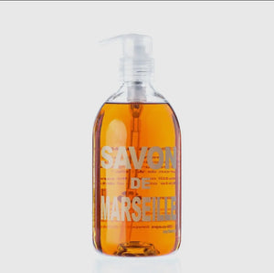 Pictured is Savon de Marseille Verbena Liquid Soap sold at The Hare & The Hart in downtown Thomasville, Georgia. It is a clear plastic bottle of amber colored soap with a label reading "SAVON DE MARSEILLE".