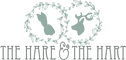 Pictured is the horizontal logo for The Hare & The Hart in downtown Thomasville, Georgia. There are two circles of greenery surrounding the two silhouettes of a hare and a stag. Below that image is text reading 