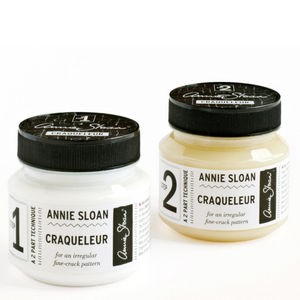 Pictured are containers of Annie Sloan® Craqueleur (Two Step Process), one of each product. This product is sold at The Hare & The Hart in downtown Thomasville, Georgia. The labels read, "1 ANNIE SLOAN CRAQUELEUR for an irregular fine-crack pattern" and "ANNIE SLOAN CRAQUELEUR for an irregular fine-crack pattern"