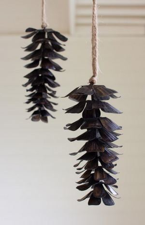 Pictured are two Antique Brown Metal Pine Cone Christmas Ornaments sold at The Hare & The Hart in downtown Thomasville, Georgia.