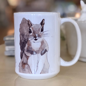 Pictured is a white coffee mug with a watercolor design of a fox on it.