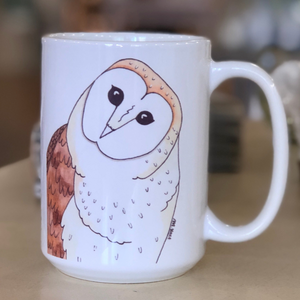 Pictured is a white coffee mug with a watercolor design of a black bear on it.