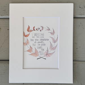 Pictured is a print designed by the artist Maddie Hart and sold at The Hare & The Hart in downtown Thomasville, Georgia. It is a print of a watercolor painting with a quote from the movie Fantastic Mr. Fox by Wes Anderson. The quote is surrounded by a wreath of orange leaves. The quote reads, "I understand what you're saying and your comments are valuable, but I'm gonna ignore you advice."