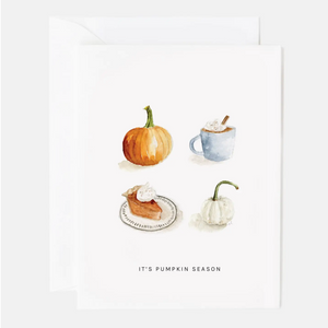 Pictured is a Pumpkin Season Notecard by Emily Lex sold at The Hare & The Hart in downtown Thomasville, Georgia. It has four watercolor illustrations on it and the words, "IT'S PUMPKIN SEASON". The illustrations are an orange pumpkin, a mug of hot chocolate with whipped cream, a plate with a slice of pumpkin pie and whipped cream, and a white pumpkin.