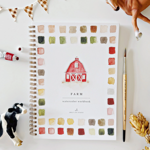 Pictured is a Farm Watercolor Workbook by Emily Lex sold at The Hare & The Hart in downtown Thomasville, Georgia. It is a watercolor workbook with farm illustrations. The cover has different watercolor paint swatches and an illustration of a barn. It reads, "FARM watercolor workbook." There is a paintbrush, a bottle of paint, a toy cow, a toy horse, and a small brown and white bunting.