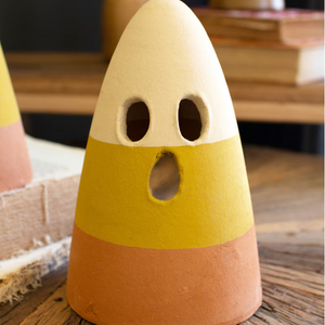 Pictured is a Terracotta Candy Corn Ghost Lantern sold at The Hare & The Hart in downtown Thomasville, Georgia. It is a candy corn-shaped terracotta decoration with a ghost face in candy corn colors.