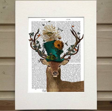 Pictured is a page out of a book framed with mat. Printed over the words on the page is the bust of a deer. The deer wears a blue top hat adorned with flowers. There are the branches of a tree coming out of the top of the hat with a birds nest in it. The antlers are covered in butterflies. There are birds and bugs howering around the hat and antlers.