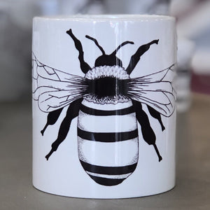A small white mug with a bee design in the center of it. This is a Small Mug by Birds & Bees sold at The Hare & The Hart.