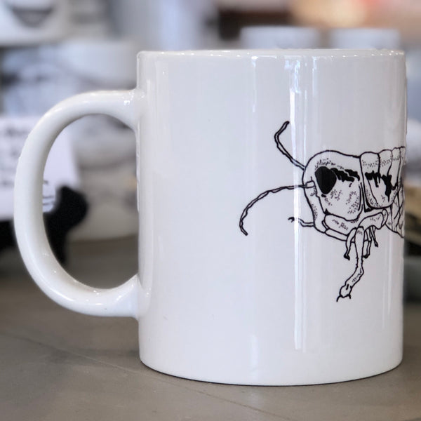 A large white mug with a black grasshopper design pictured from the side. This is a Large Mug by Birds & Bees sold at The Hare & The Hart.