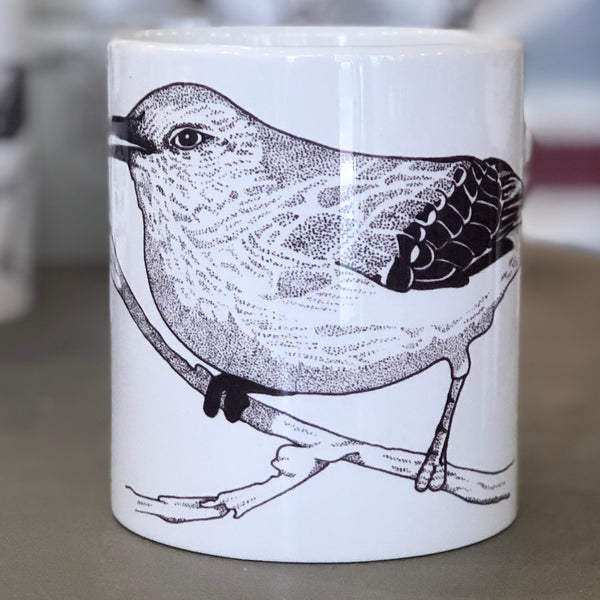 A large white mug with a bird design in the center of it. The bird is drawn in the style of pointillism. This is a Large Mug by Birds & Bees sold at The Hare & The Hart.