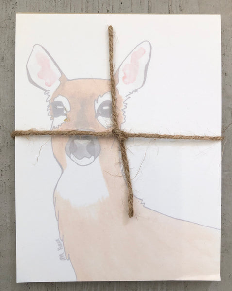 There is a notepad tied together with twice. The paper of the notepad is printed with a design of a doe.