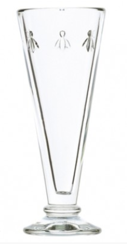Pictured is a clear glass champagne flute. There are three bees embossed in it near the top edge of the glass. This is a Bee Champagne Flute by La Rochere sold at The Hare & The Hart.