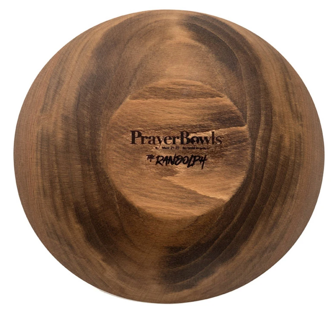 Pictured is the bottom of the Randolph Prayer Bowl. It is all natural wood, except for the carved Prayer Bowls logo on the base