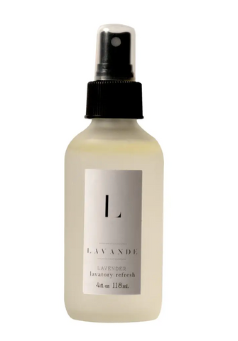 Pictured is a Lavande Room Spray bottle. The glass is frosted and it has a spray cap. The liquid inside is clear. The Lavande label on the outside is a white sticker with black text.
