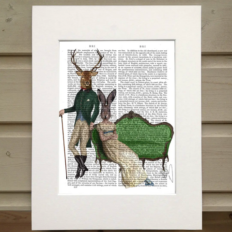 Pictured is a page from a book framed with mat. Printed over the page are two figures and a couch. One figure wears an old horesback riding outfit and holds a cane. The other sits on an old fashioned green couch. The figure on the couch wears on old dress with an empire waist. The figure standing has the head of a deer with antlers. The figure sitting on the couch has the head of a rabbit or hare.