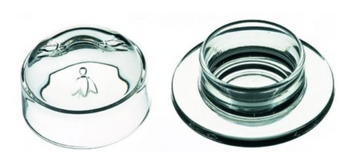 A round glass butter dish is pictured. The lid of the dish is on the left and it has three bees embossed on it. The base of the dish is on the right and it has a wide lip around the bottom edge. This is a Bee Butter Dish by La Rochere sold at The Hare & The Hart.