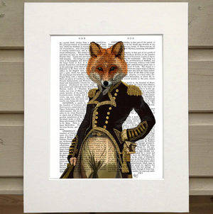 Pictured is a page from a book framed in mat. Printed over the words on the page is an illustration of a figure wearing a black, old fashioned military jacket with gold detals and buttons. The figure has one hand on its hip and the other hanging at its side. The figure has the head of a fox instead of a human head. It is an Admiral Fox Book Print by FabFunky Ltd. sold at The Hare & The Hart.
