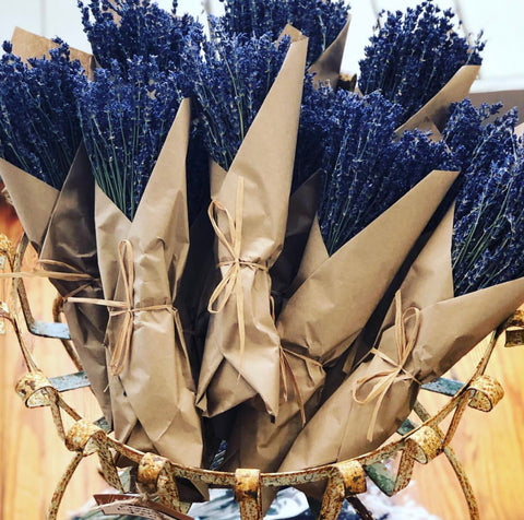 Pictured are several bundles of French lavender. They are wrapped in crisp brown paper and tied with twine. These are French Lavender Bundles by Mills Floral sold at The Hare & The Hart.