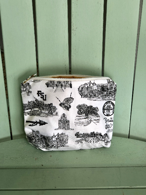 Pictured is a small fabric cloth with an opening at the top with a zipper closure. The fabric on the outside of the pouch is Toile of FSU fabric in black and white.
